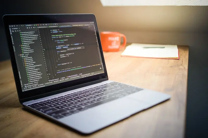 Web developer's workspace with a laptop showing code